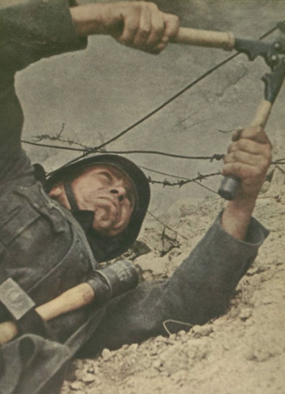 German soldier on the field cutting barbed wire 